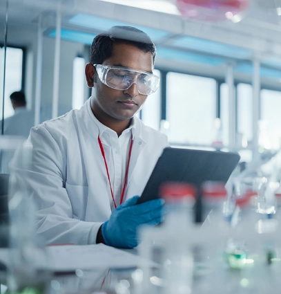 A person wearing goggles and looking at a tablet